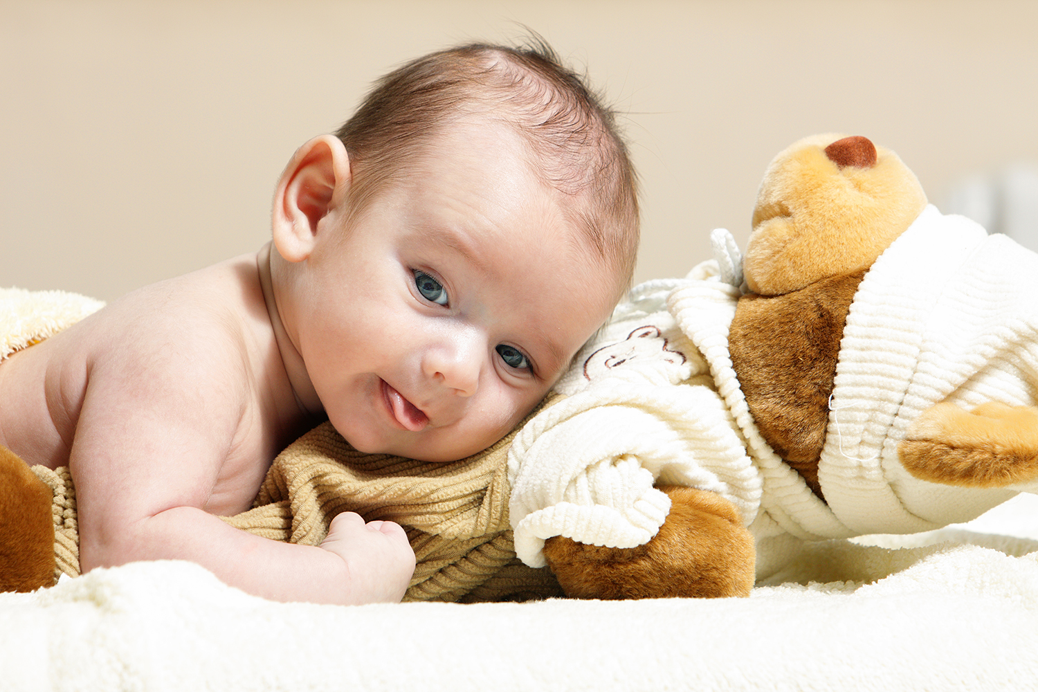 En baby der ligger med hovedet ovenpå en blød bamse