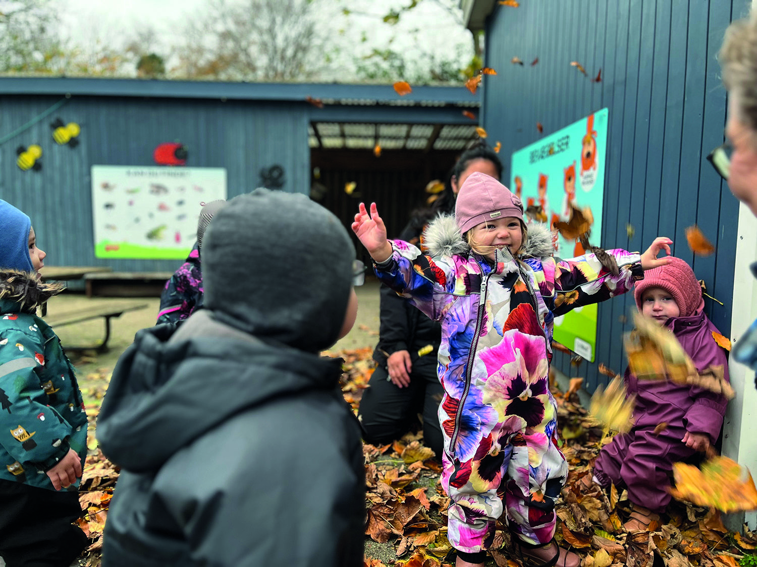 Børnehavebørn der leger i blade
