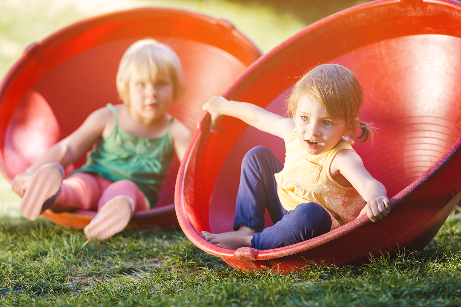 2 børn der leger med hver deres snurretop