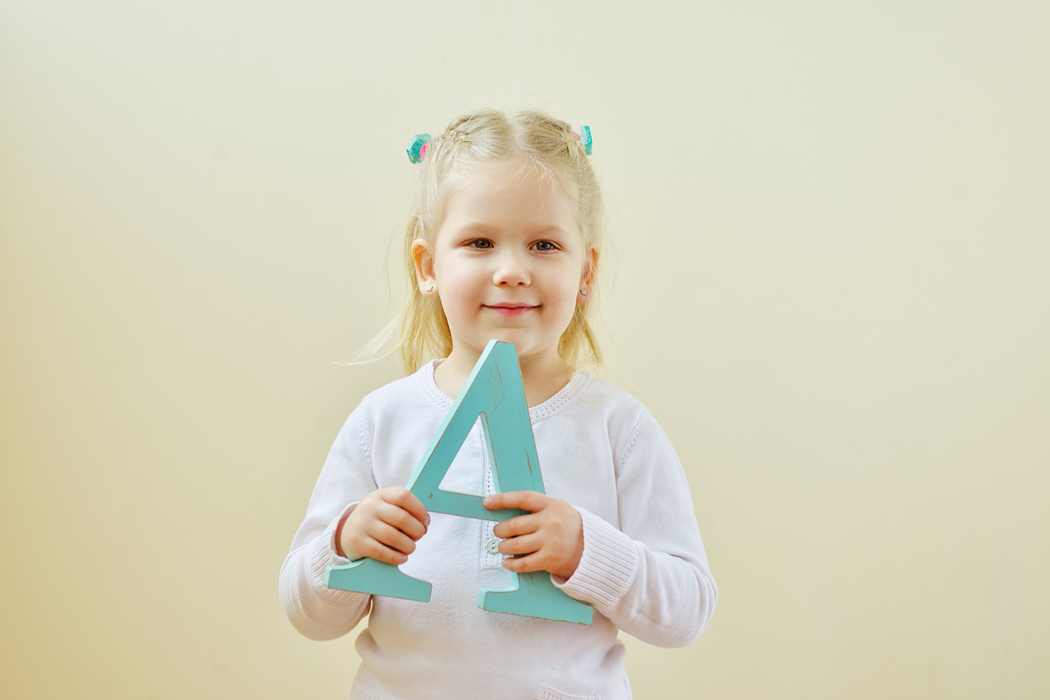 Pige der står med et bogstavet a i hendes hænder