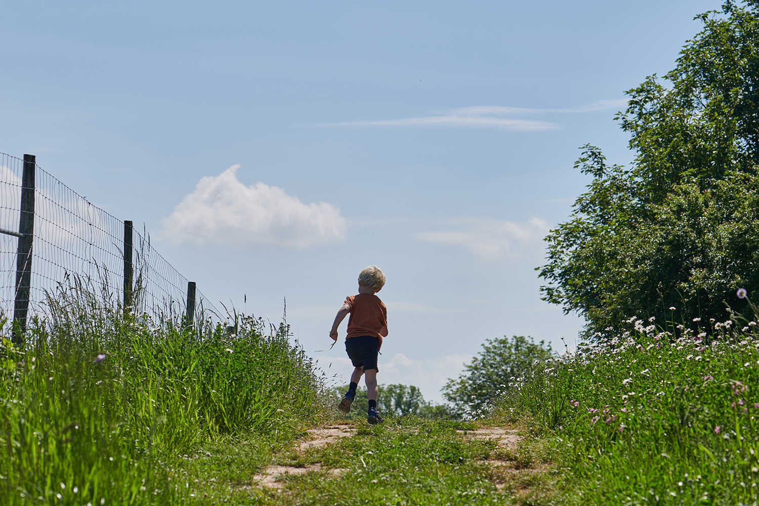 Dreng der løber på en marksti